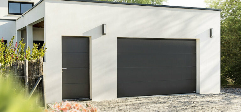 Porte de garage sectionnelle SWIFT40 isolante et personnalisable avec ouverture verticale, hublots, portillon intégré et motorisation.